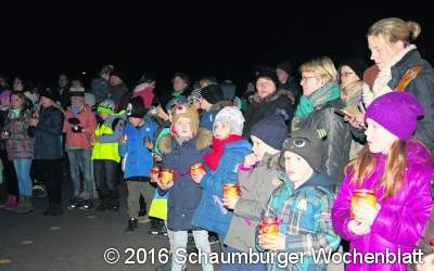 Grundschüler tragen singend Lichter in die Welt und auf den Schulhof in Evesen