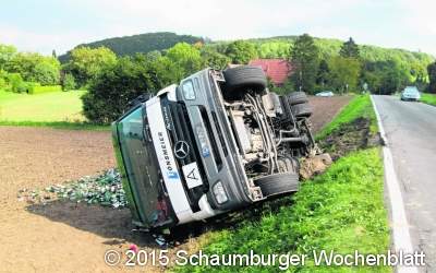 Sattelzug kippt auf einen Acker