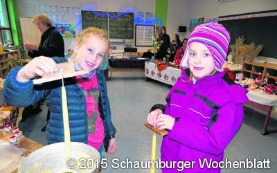 Carlotta und Lina ziehen Kerzen für Adventskranz
