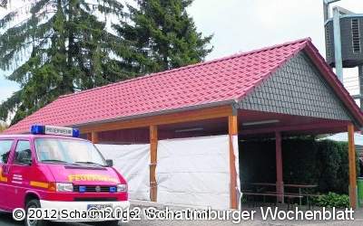 Ein großes Dach schützt ein Auto und zwei Garagen