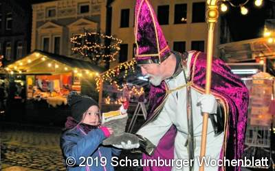 Der Nikolaus übergibt den Kindern ihre Stiefel