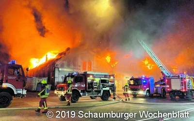 Feuerwehrleute stehen Flammenwand gegenüber