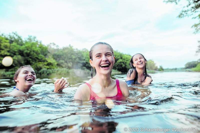 Enjoying forest party with friends. Group of beautiful happy young men and girls swimming at the river together. Summer, party, adventure, youth, frienship concept